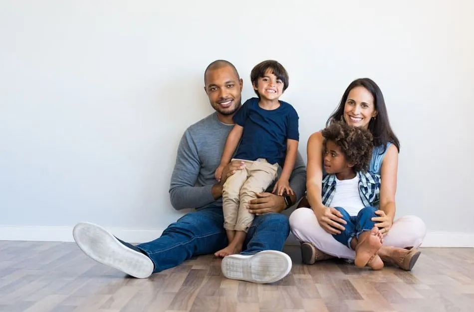 Family sitting on the floor together smiling