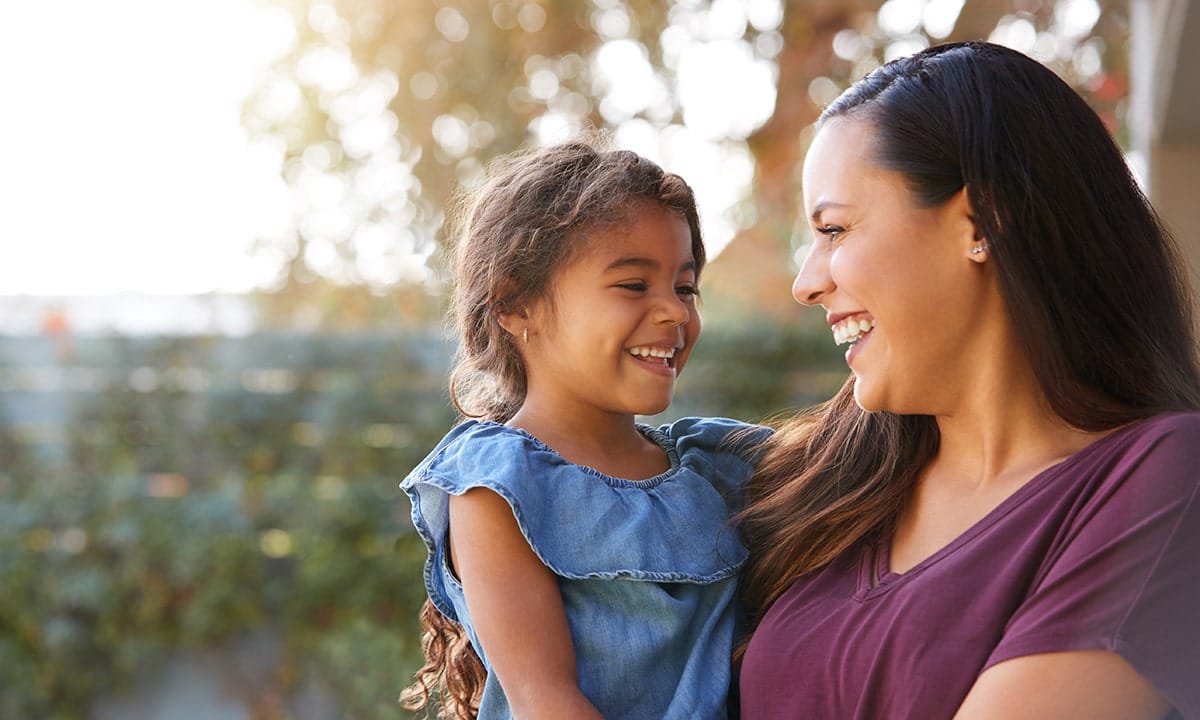 Hispanic mother and young child smiling at each other